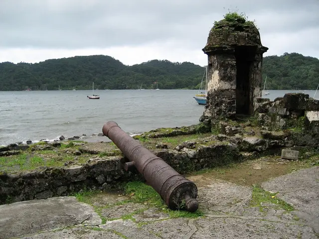Um canhão e uma guarita de pedra nas fortificações à beira-mar de Portobelo.